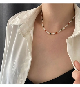 Detail of beaded necklace with freshwater pearls and natural stones on model's neck