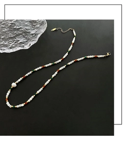 Close-up of handmade beaded necklace with freshwater pearl and vintage natural stones