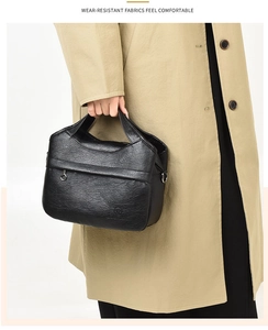 Close-up of black lychee texture handbag featuring metal zippers and side strap hooks