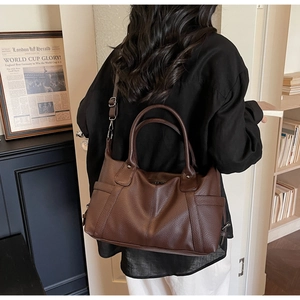 Detail view of large dark brown tote with lychee pattern texture and V-line stitching