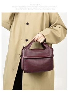 Close-up of deep burgundy litchi texture handbag with embossed logo and metal side buckle