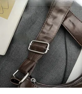 Detail of dark brown leather strap with silver adjustable buckle and stitching