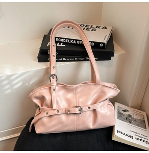 Détail du sac à épaule en cuir rose avec boucle argentée et design plissé élégant