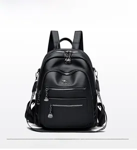 Detail of black lychee grain leather backpack with kangaroo logo and silver zippers