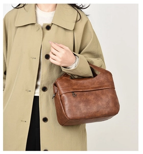 Close-up of a vintage brown leather handbag with pebble texture and brand logo embossing