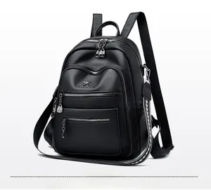 Close-up of black pebble leather backpack with silver kangaroo logo and textured strap