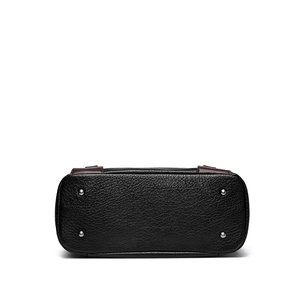 Vue du fond d'un sac cabas en cuir noir avec quatre pieds de protection en métal