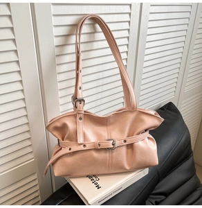 Détails d'un sac à main rose en cuir avec boucles argentées et texture plissée souple