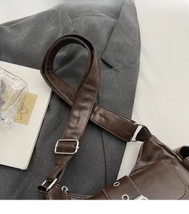 Detail of wide comfortable shoulder strap with silver buckles on a brown vintage bag