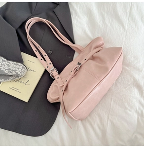 Gros plan sur un sac à bandoulière en similicuir rose avec boucle argentée sur tissu