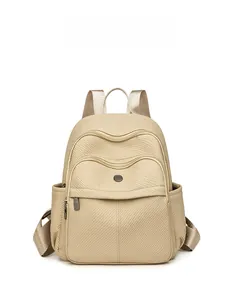 Close-up of beige nylon backpack featuring triple zipper compartments and metal logo