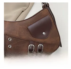 Detail of vintage brown saddle bag with metal eyelets and premium leather stitching