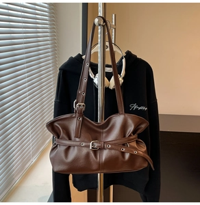 Détail du sac cabas en simili cuir marron foncé avec plis vintage et boucles métalliques