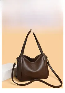 Detail of dark brown pebble leather tote bag with gold hardware and side rivets