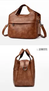 Detail view of brown faux leather handbag with zip pocket and embossed kangaroo logo