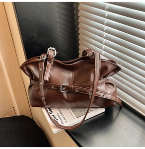 Détail du sac bandoulière vintage en cuir marron plissé avec boucles en métal argenté
