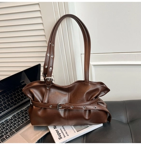 Détails du sac bandoulière marron vintage avec œillets métalliques et lanière à boucle