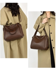 Detail of dark brown pebble leather tote bag with gold studs and adjustable strap