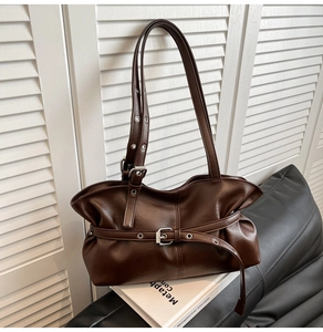 Détail du sac vintage en similicuir marron foncé avec boucle métallique et style Y2K