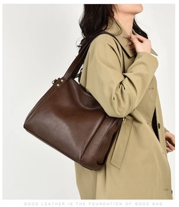 Close-up of coffee brown lychee pattern leather texture on a stylish bucket bag