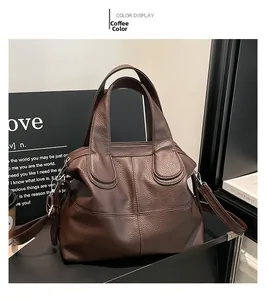 Detail of coffee brown leather tote bag with wide handles and detachable shoulder strap