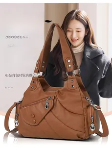 Dettaglio borsa a tracolla in pelle lavata con cuciture diagonali e zip decorativa