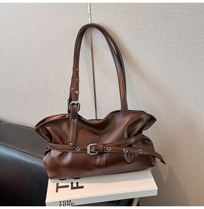 Détails d'un sac à main rétro marron foncé avec boucles élégantes et texture plissée