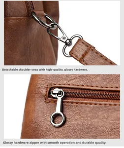 Detail of silver metal hooks and circular zipper pulls on a brown leather handbag