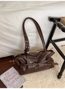 Détail du sac cabas vintage marron foncé avec œillets métalliques et boucle sur tapis