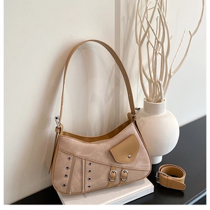Close-up of beige shoulder bag showing mixed suede texture and metallic buckles