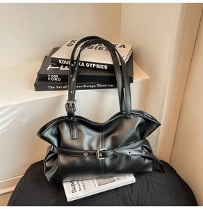 Détail du grand sac vintage noir avec boucles métalliques et plis en cuir souple