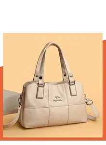 Detail view of lychee texture faux leather handbag with metal buckle and shoulder strap