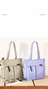Detailweergave van grijze en lavendelkleurige shoppers met meerdere zakken en nylon riemen