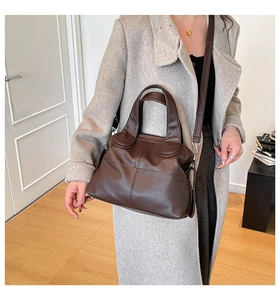 Close-up of brown litchi pattern leather handbag with reinforced handles and silver buckle