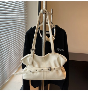 Détail du sac nuage plissé blanc avec sangles décoratives à boucles et texture en similicuir