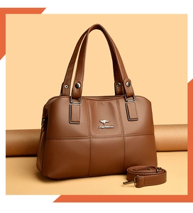 Détail du sac seau en cuir marron avec logo kangourou argenté et bandoulière amovible