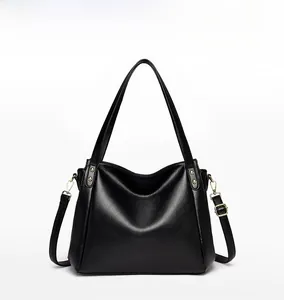 Front view of black pebble leather bucket bag with gold rivets and adjustable straps