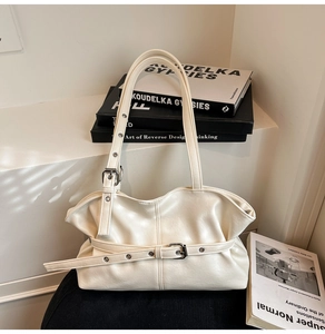 Détail du sac cabas en similicuir blanc crème montrant les boucles en métal argenté