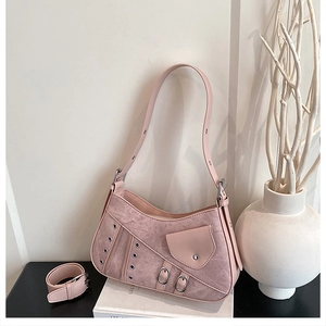 Detail of pink shoulder bag featuring metal eyelets, buckles and textured leather finish