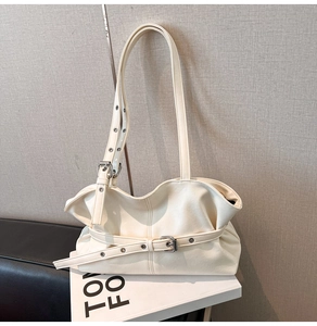 Détail du sac cabas blanc crème avec boucle métallique et œillets sur la bandoulière