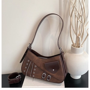 Close-up of retro brown shoulder bag with silver eyelets and zipper detailing