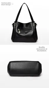 Detail view of black tote bag back zipper pocket and wide bottom with gold heart charm