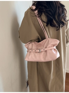Détail du sac à bandoulière plissé rose avec boucle argentée porté par un mannequin