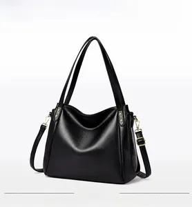 Detail of black pebbled leather bucket bag with gold hardware and detachable strap
