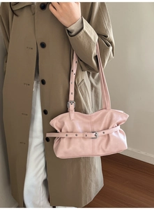 Gros plan du sac sous le bras rose clair avec boucles décoratives et détails argentés