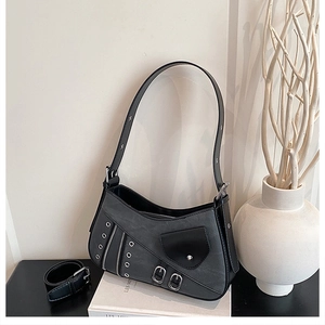 Detail of punk style underarm bag with silver metal eyelets and decorative buckles