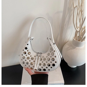 Detailed view of a white hobo bag featuring polished silver rivet studs decoration
