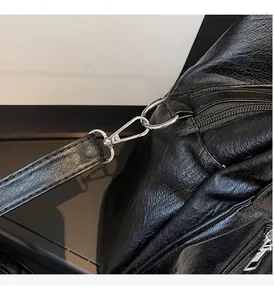 Close-up of black litchi pattern leather bag with silver metal swivel hardware and zipper