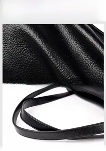 Detail of high-quality black lychee textured leather and durable double-stitched handle