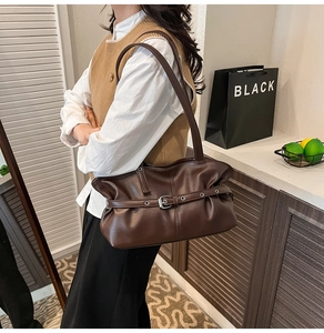Détail du sac bandoulière en cuir plissé marron foncé avec boucles argentées décoratives